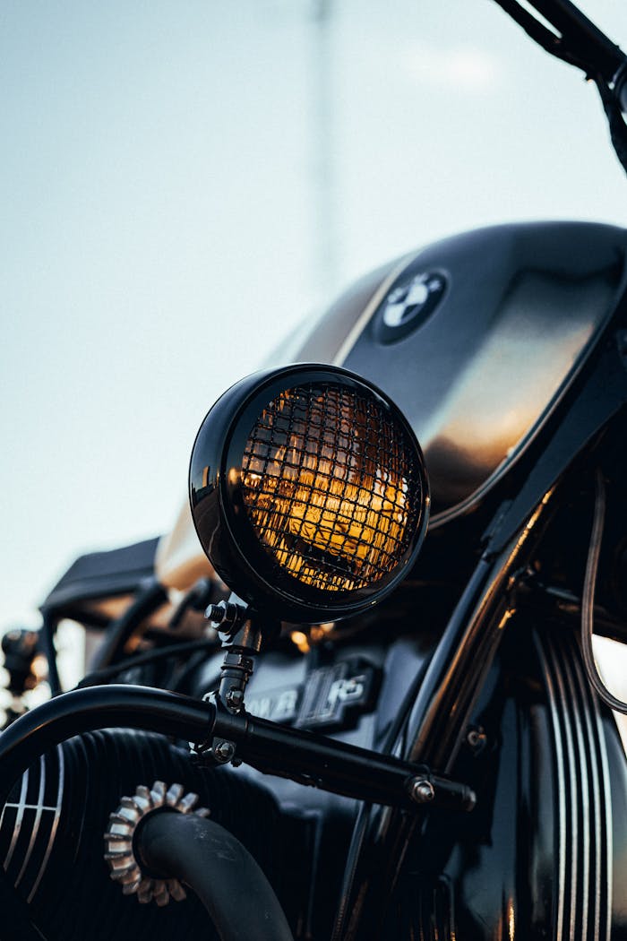 our-services-1 Close-up of a vintage motorcycle headlight with a glazed finish during sunset.